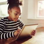 Young Black Girl Browsing On A Tablet Pc