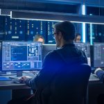 Team Of IT Programers Working On Desktop Computers In Data Center Control Room. Young Professionals Writing On Sophisticated Programming Code Language